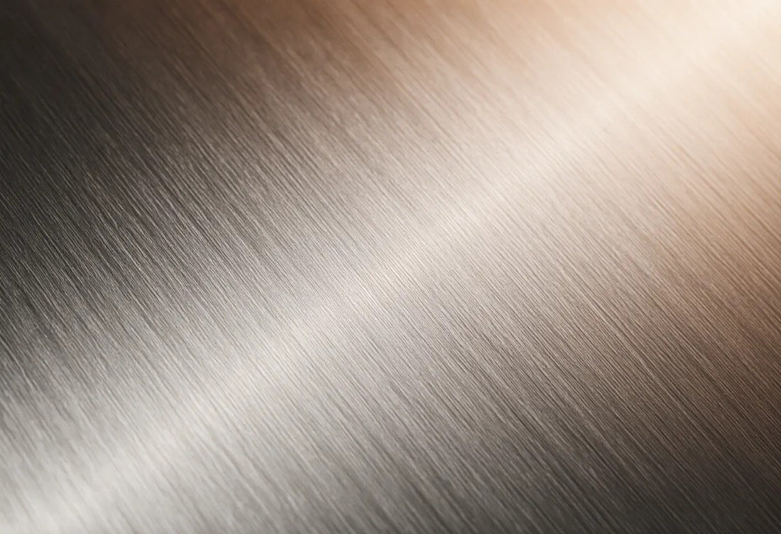 Close-up of brushed stainless steel surface texture in soft directional light