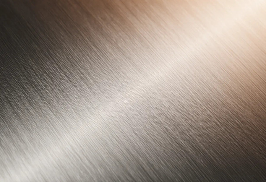 Close-up of brushed stainless steel surface texture in soft directional light