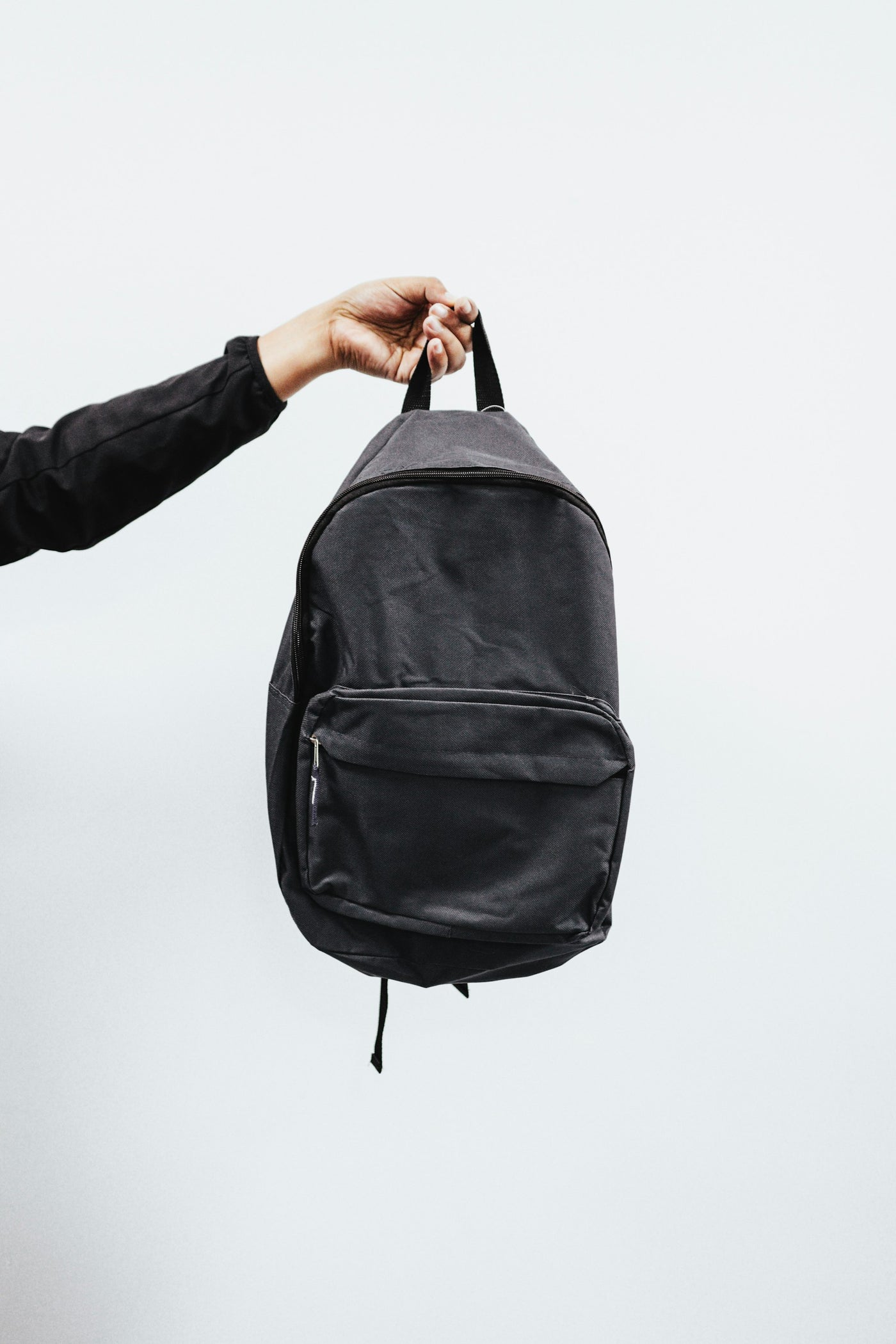An organised travel pouch with passport, pen and small carry essentials on dark linen.
