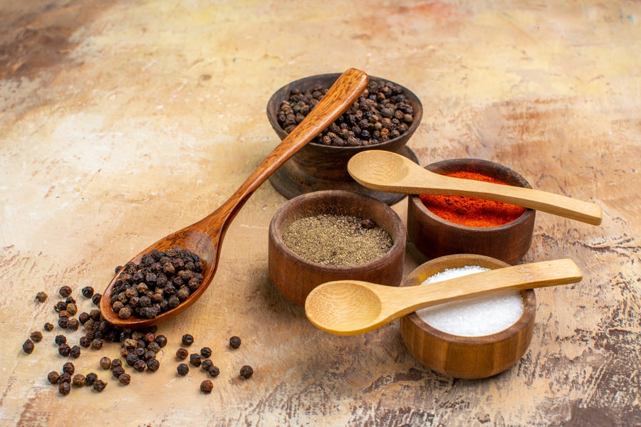 Single-origin spices in small wooden bowls — the kind sourced from named family farms