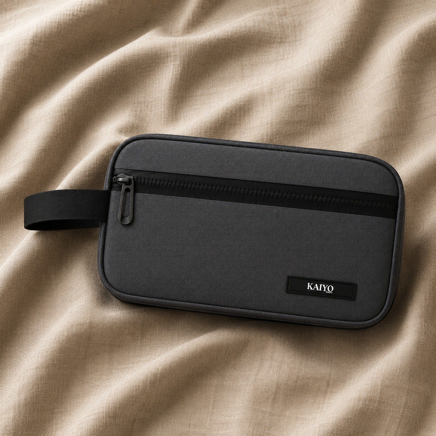 Ginza Toiletry Pouch in Tokyo Noir resting on natural oatmeal linen